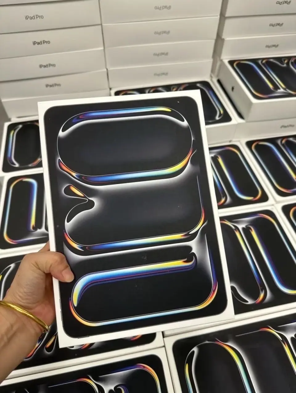 iPad Pro M4 retail box held in front of recent boxed supplier inventory